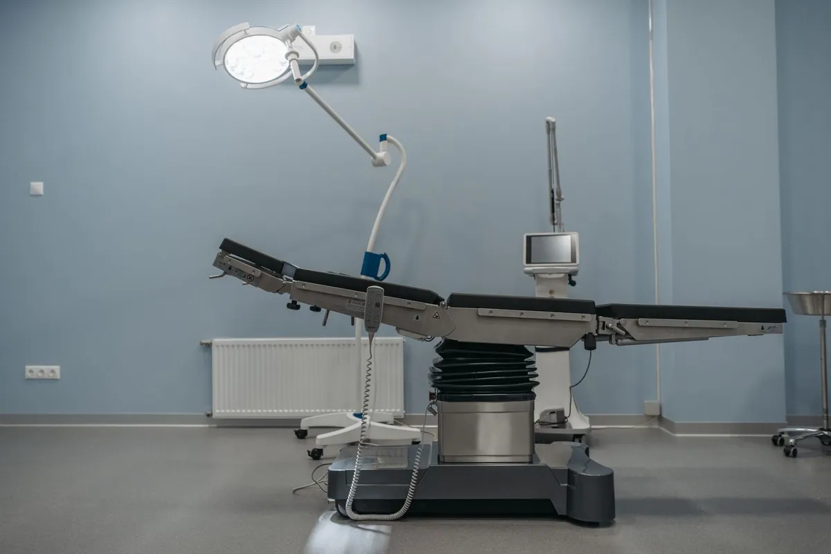 An operating room between cases, with the surgical table positioned under the theatre light.